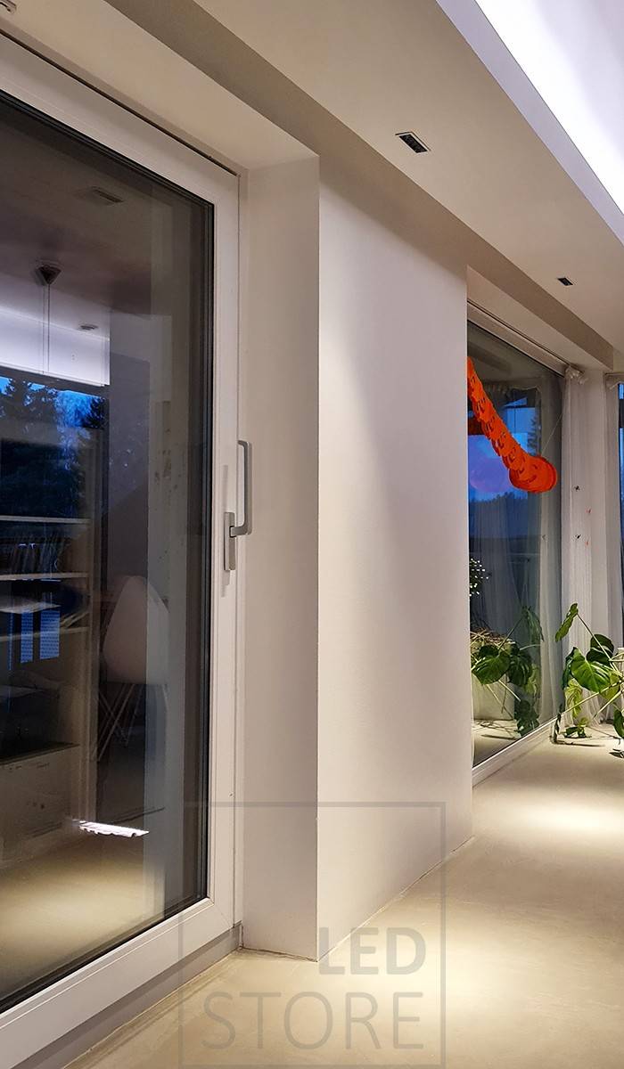 En el salón, una estantería desplegable con luminarias Linja5 empotradas. Tira de LED montada sobre la estantería para proporcionar una iluminación ambiental indirecta en el espacio. Ledstore.fi